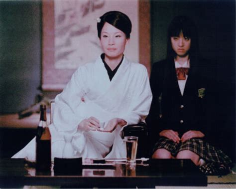 lucy liu sits at japanese dining table with beer and sake kill bill
