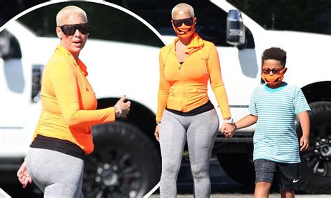 amber rose shows off her curves in yellow hoodie and gray leggings on