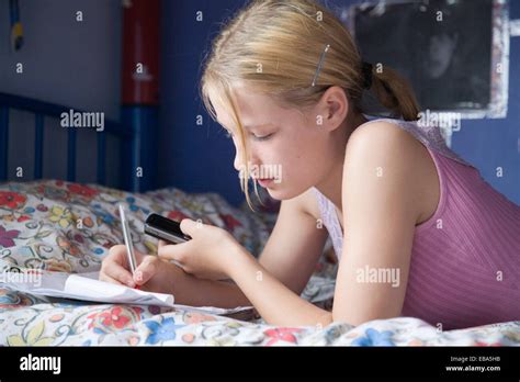Teenager Mädchen Auf Ihrem Bett Liegend Mit Handy Und Schreiben