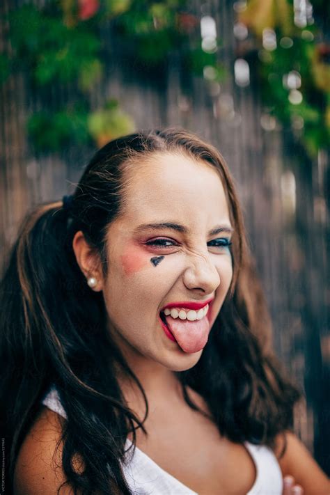 teenager girl with punk makeup sticking out tongue