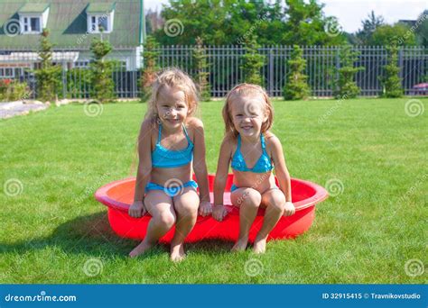 Two Little Sisters Frolicing And Splashing In Stock Image Image Of