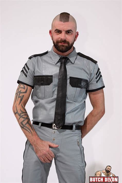 hairy cop with tattoos and a mohawk plays with his nipples and uncut cock as he strips