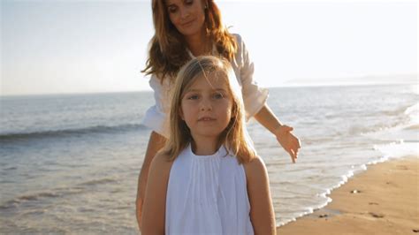 mother cuddling daughter  beach stock footage sbv  storyblocks