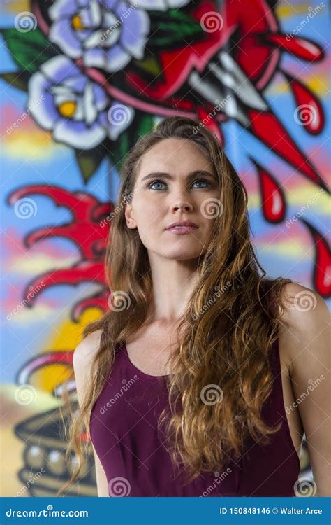 Lovely Brunette Model Posing Outdoors Against Graffiti Editorial Photo