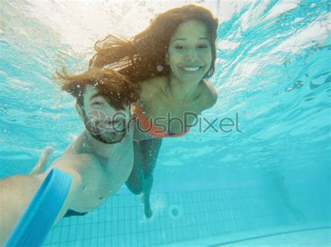 handsome couple taking selfie under the water in swimming