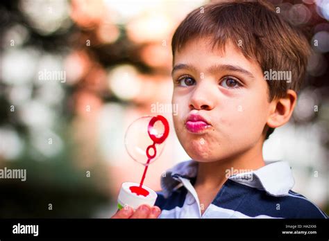 boy holding bubble wand blowing soap bubbles stock photo alamy