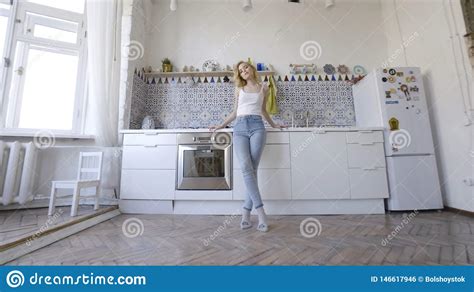 bionda sexy rilassata che posa sulla cucina nella mattina azione