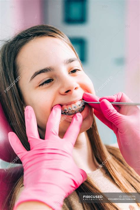Female Orthodontist Fixing Dental Braces Of Girl In Clinic — Treatment