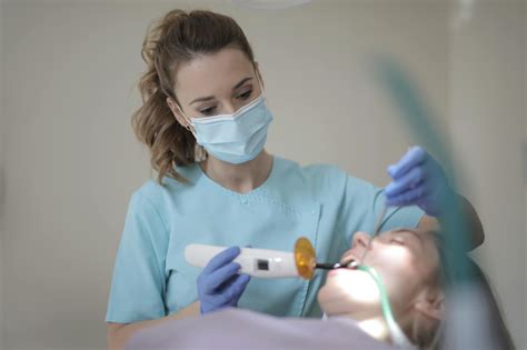 young female dentist treating teeth  patient  instruments