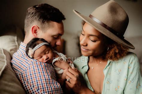 father holding  baby daughter   shoulder mom