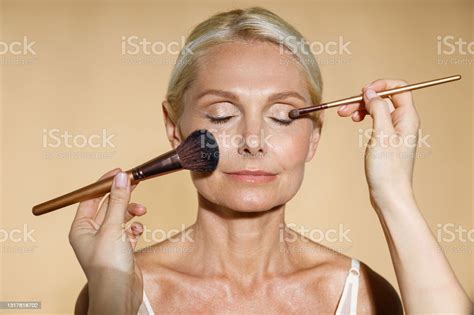 Close Up Of Hands Of Skillful Artist Doing Natural Makeup For Mature