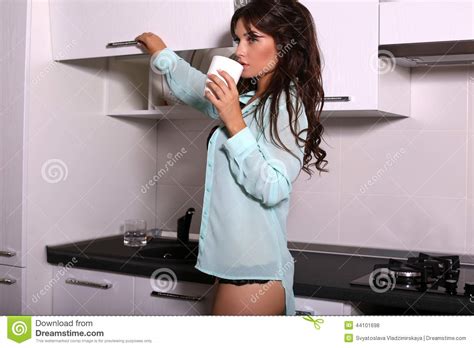 beautiful girl with dark hair drinking a coffee on kitchen