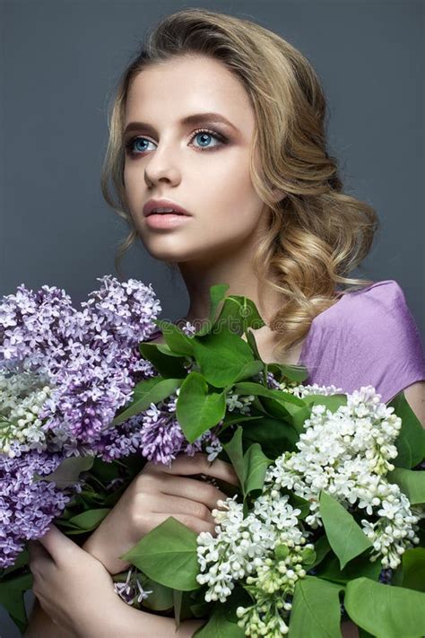 Beautiful Girl In A Purple Dress And A Bouquet Of Lilacs The Model Is
