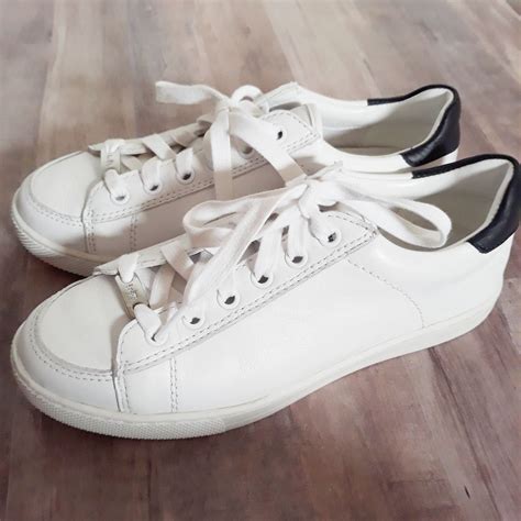 white leather tennis shoes  coach features black heels  silver tag  laces super clean