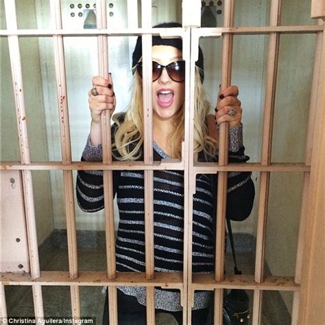christina aguilera sports stripes as she poses behind bars at alcatraz