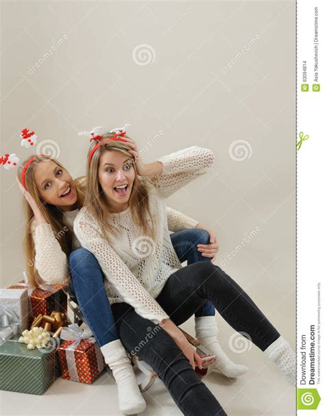 twee mooie meisjes die pret op oude uitstekende slee met giften fo hebben stock foto image