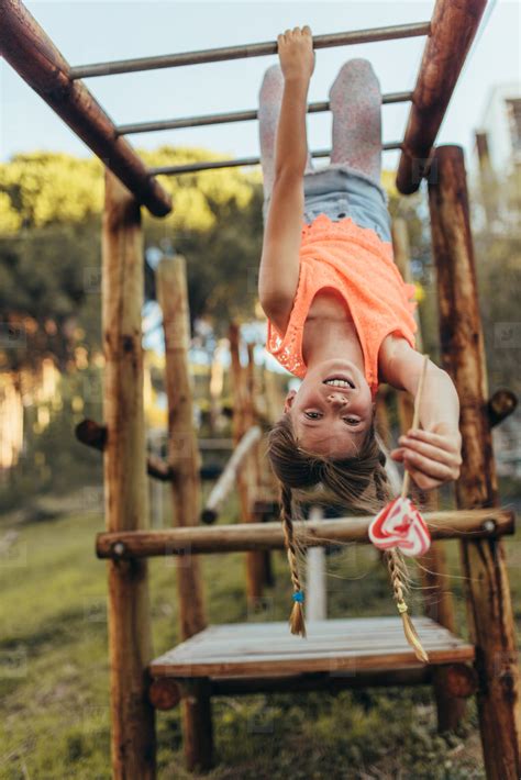 photos girl hanging upside down on a horizontal ladder