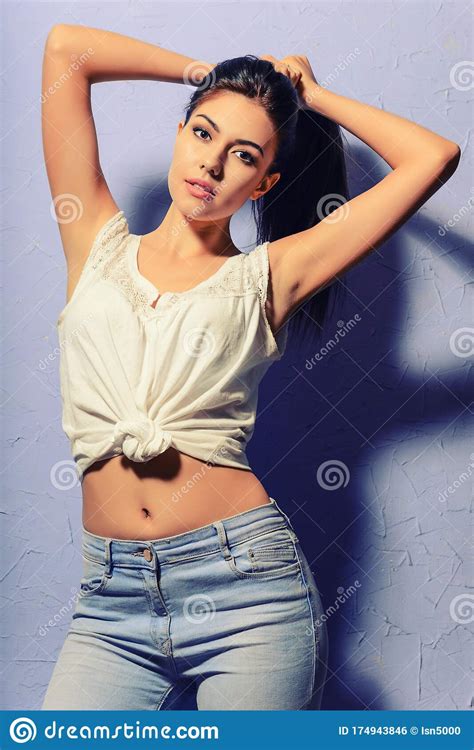 Sexy Bronceado Morena Chica En Un Chaleco Blanco Y Jeans Foto De
