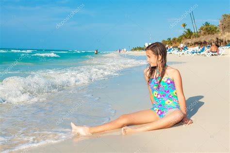 leuke spaanse tiener zittend op een zonnig strand in cuba — stockfoto © kmiragaya 24119017