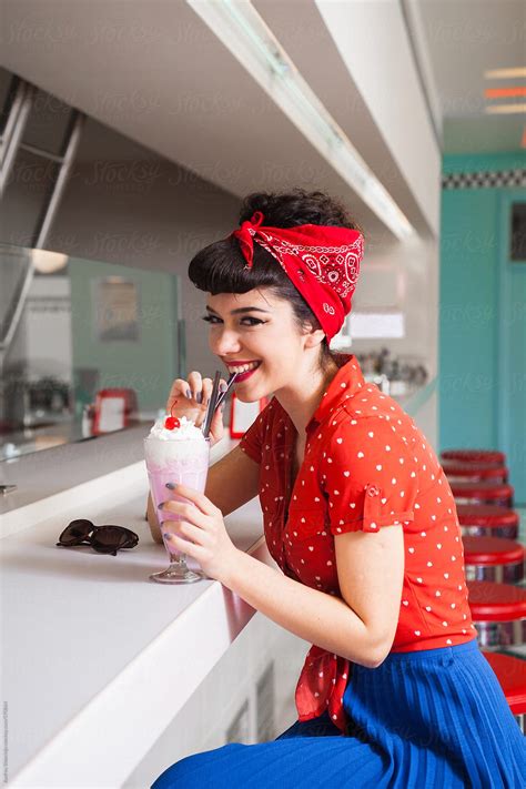 Stylish Rockabilly Pin Up Girl Enjoying Milkshake At Bar