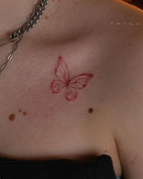Red Ink Butterfly Tattoo On The Collarbone