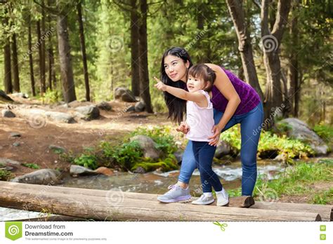 asian woman with her little daughter in the woods near the