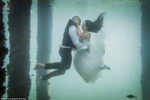 Bride Takes The Plunge In White Wedding Dress For Underwater Photo With