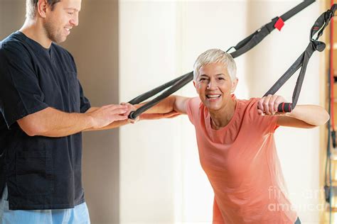 senior woman with personal trainer photograph by microgen images