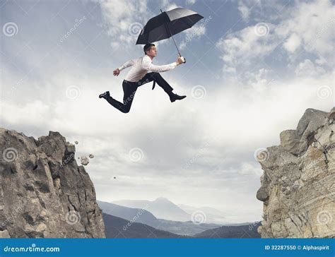 businessman jumping   mountains stock photo image