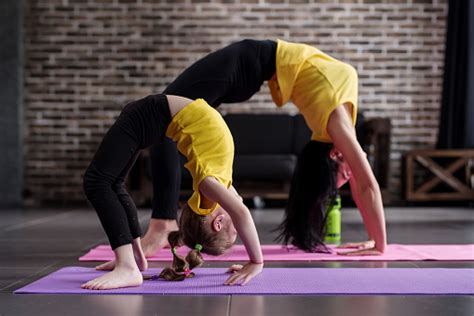 Two Flexible Girls Of Different Age Doing Upward Facing Bow Yoga Pose
