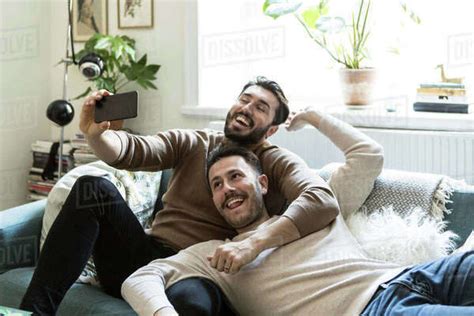 Happy Gay Couple Taking Selfie Through Mobile Phone While
