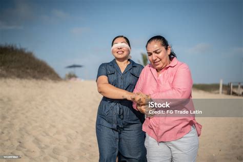 lesbian woman making a surprise to her wife with eyes with a blindfold