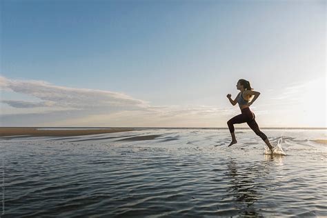 Beautiful Fit Female Athlete Running On Beach By Stocksy Contributor