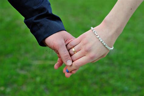 Wedding Couple Holding Hands On Grass Background Stock