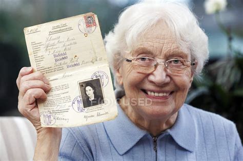senior woman showing her old temporary passport — senior adults image