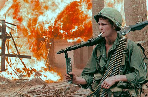 army  machine gunner  front   burning hut south vietnam
