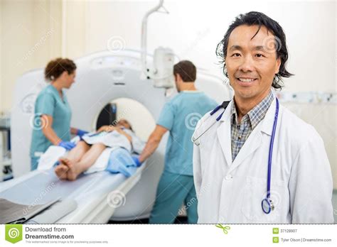 radiologist with nurses preparing patient for ct stock