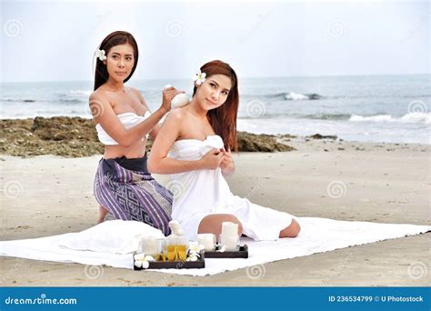 Two Asia Women Doing Spa Massage Together On The Tropical Beach Stock