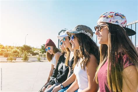 girls sitting in a row by stocksy contributor victor torres stocksy