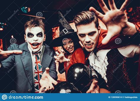 group of friends in halloween costumes having fun stock