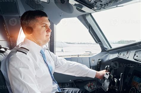 side view pilot  formal wear sits   cockpit  controls