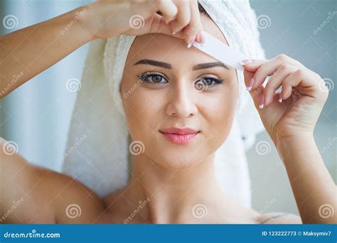 beautician waxing young womans eyebrows  spa center stock image