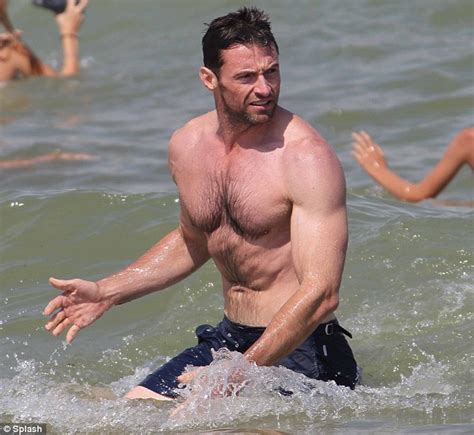 shirtless hugh jackman springs into action as he hits the beach in st