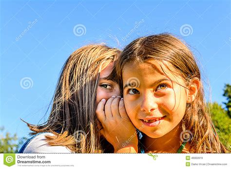 due bambine che bisbigliano i segreti immagine stock