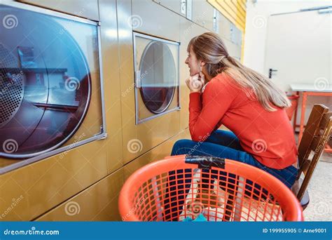 woman waits on chair in front of washing machine stock image image of