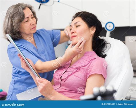 Experienced Cosmetology Doctor Examines A Young Woman Patient Before