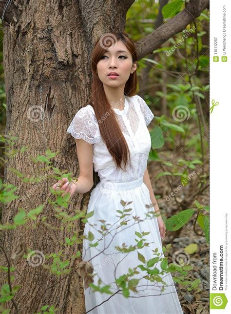 mooi aziatisch meisje die onder een boom rusten stock