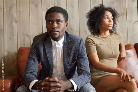 Frustrated Upset African Couple In Quarrel Sitting On Sofa Not Talking