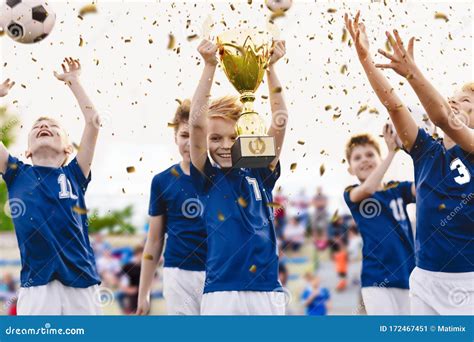 champion youth soccer team  winning trophy boys football team celebrating victory  school