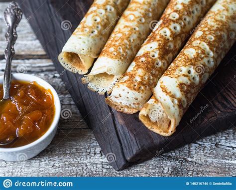 russian homemade yeast pancakes rolled into a tube on wood
